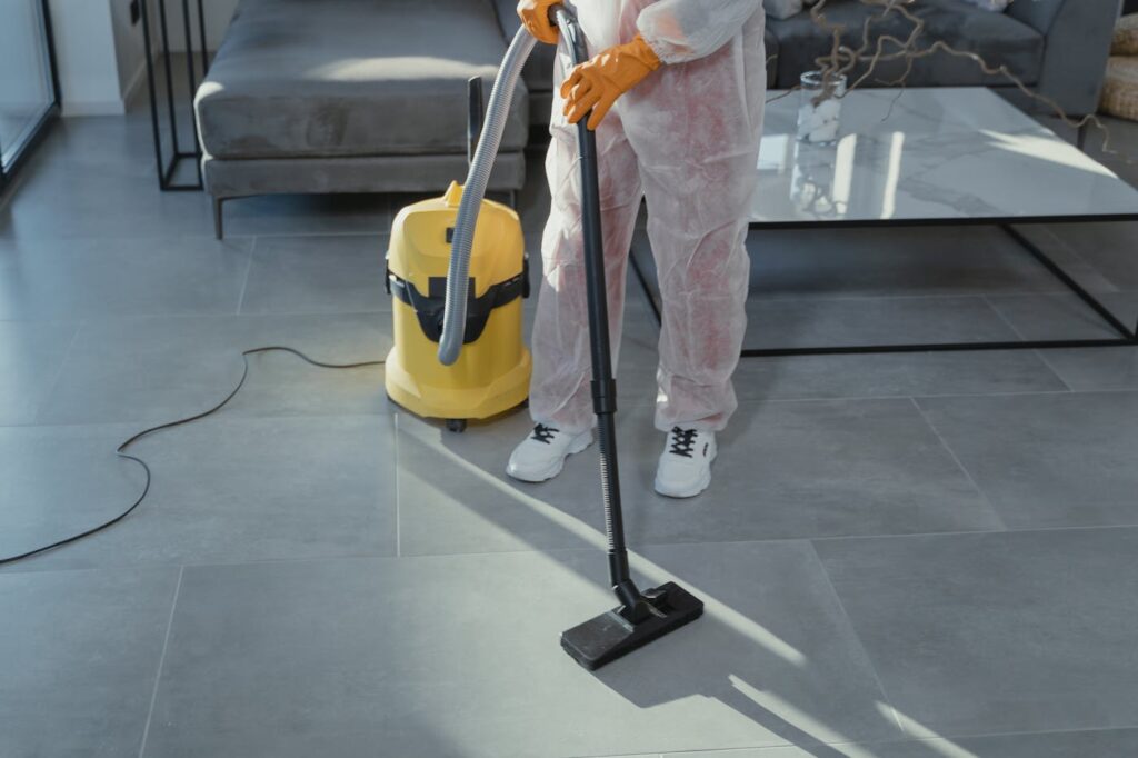 Professional cleaner vacuuming a modern living room floor